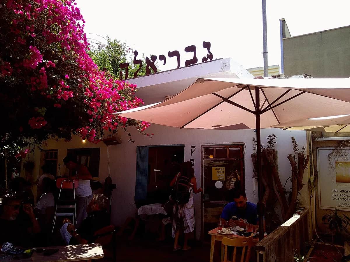 בית קפה עם בוגנוויליה ורודה ושמשייה בהירה, צולם ברולוסנאפ