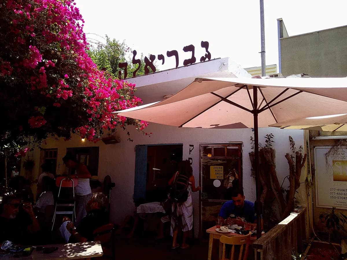 בית קפה עם בוגנוויליה ורודה ושמשייה בהירה, צולם ברולוסנאפ